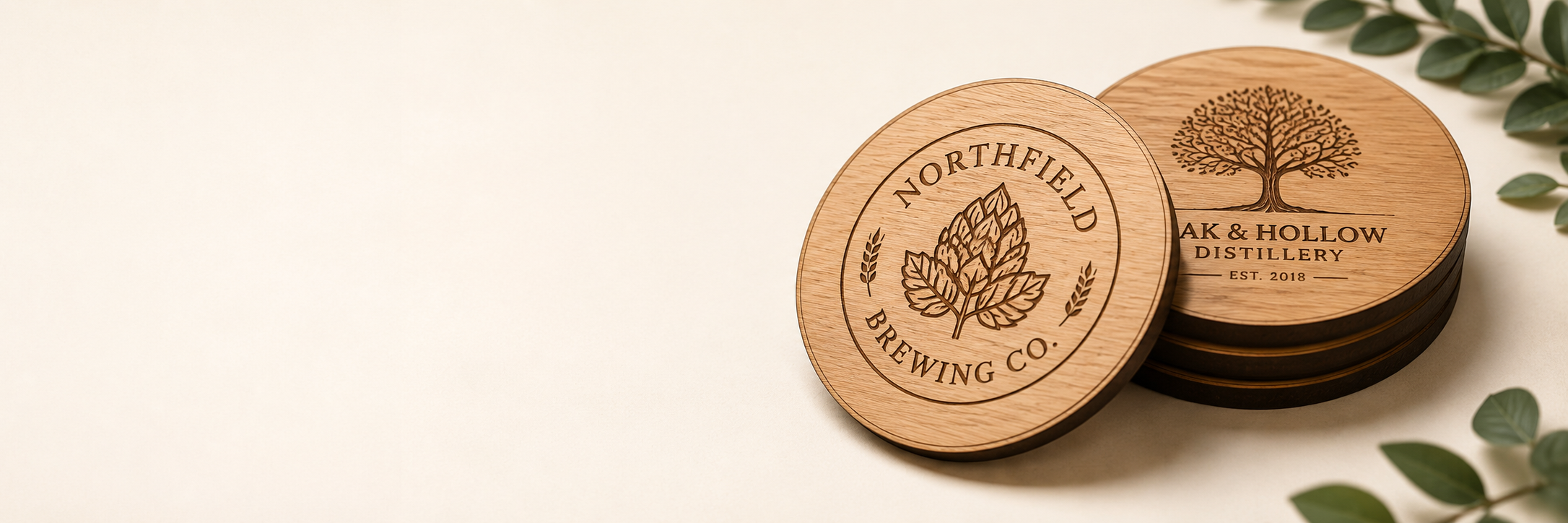 Two round wooden beer coasters stacked on a light beige background, with engraved brewery logos and leaf illustrations. One coaster is shown from the top, displaying the 'Northfield Brewing Co.