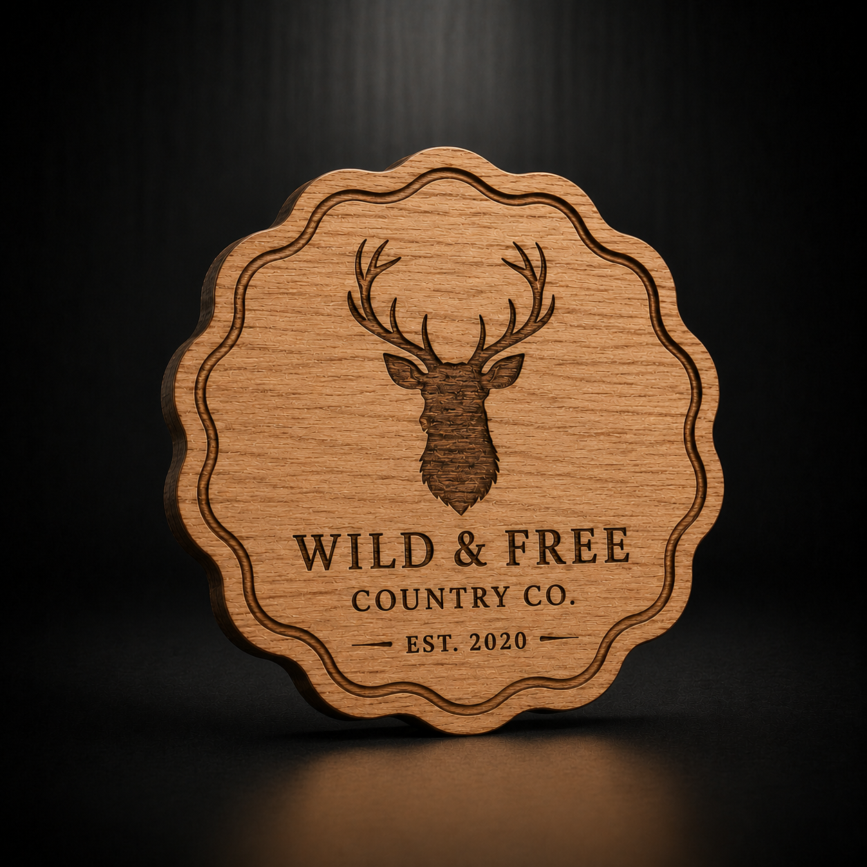 A scalloped-edge wooden plaque or coaster featuring a laser-engraved deer head and the text 'WILD &amp; FREE COUNTRY CO. EST.